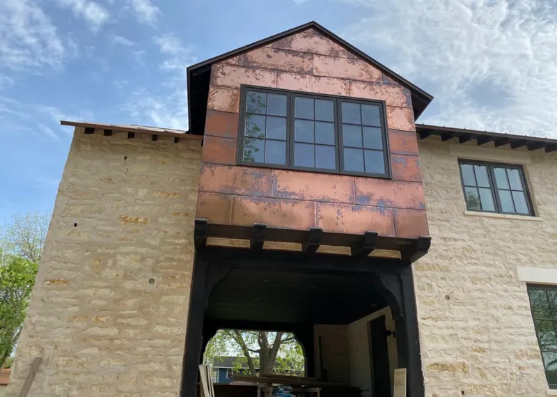 Copper metal panel facade on a stone building for Roof Repair in Mexia